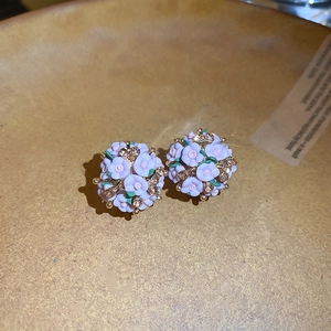 Macro shot of purple ceramic flower cluster earrings with sparkling rhinestones and gold beads
