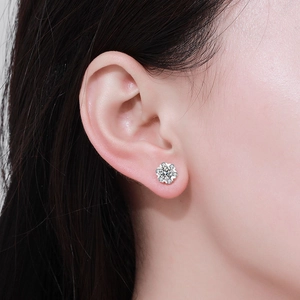 Detail shot of a snowflake moissanite earring in 925 sterling silver worn by a model