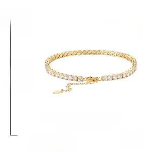 Detail of gold tennis bracelet with zircon stones, lobster clasp, and heart pendant