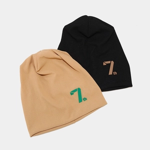 Detail of khaki and black ribbed knit beanies featuring stylized 7th letter printing