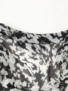 Nahaufnahme des schwarz-weißen abstrakten Tintendruckmusters auf dem Chiffon-Minikleid