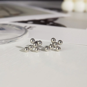 Macro shot of polished stainless steel ball cross stud earrings for women with mirror finish
