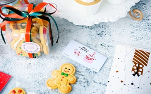 Detailed view of gingerbread man and house cookies in gift box with red green ribbon