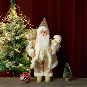 Close-up of Santa doll in gold and beige embroidered coat holding a small teddy bear
