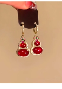 Detailed macro view of 14k gold plated red gourd earrings with sparkling zircon accents