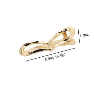 Golden wavy metal hair clip with heart shape and textured surface measurements shown