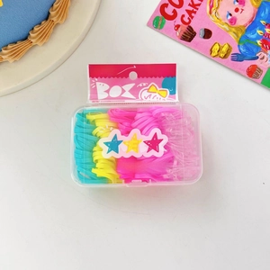 Dettaglio di elastici per capelli colorati in scatola trasparente con elastici blu, gialli e rosa