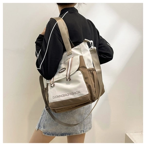 Detail einer zweifarbigen Canvas-Tasche mit großer Vordertasche als Umhängetasche getragen