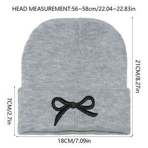 Tableau des tailles détaillé pour bonnet en tricot gris avec nœud noir brodé