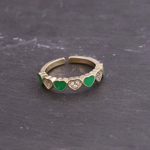 Macro detail of gold adjustable ring featuring green enamel hearts and white zircon inlay