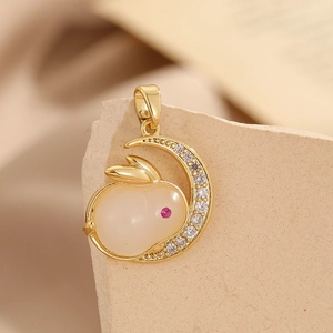 Macro view of a gold-plated crescent moon and rabbit pendant with sparkling crystals