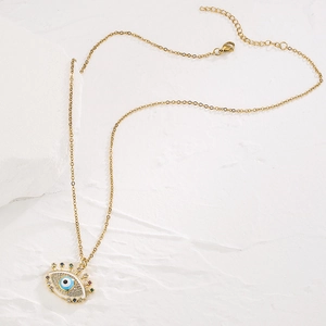 Gold plated copper necklace with evil eye pendant and zircons on white stone base