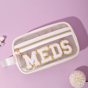 Dettaglio borsa trucco in PVC con lettere MEDS in ciniglia e cerniera dorata