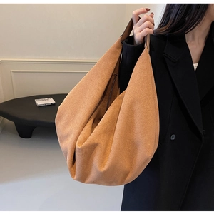 Detailed side view of large camel suede hobo bag on model showcasing size and draping