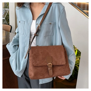 Brown frosted leather crossbody bag with flap buckle shown on shoulder for daily wear