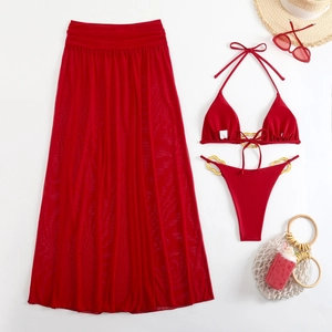 Flat lay of red three-piece bikini set with sheer mesh skirt and gold ring details