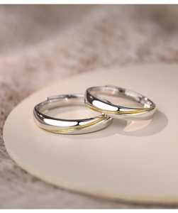Macro shot of S925 sterling silver couple rings with gold textured groove details
