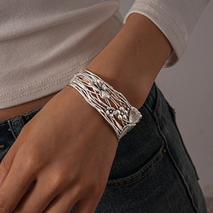 Detail of vintage silver open cuff bracelet with hollow mesh and 3D butterfly floral motif