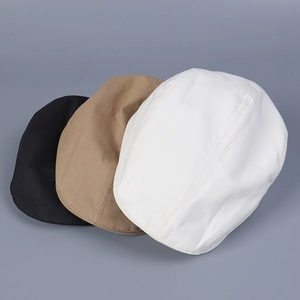 Detailed overhead view of cotton twill flat caps in black, khaki, and white colors
