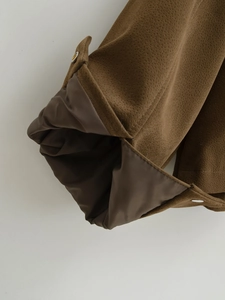 Detailansicht der braunen Wildlederjacke mit glattem Innenfutter und glänzenden Metallknöpfen