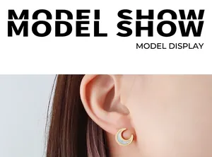 Detail of moon-shaped gold earring with white shell inlay worn on a model ear