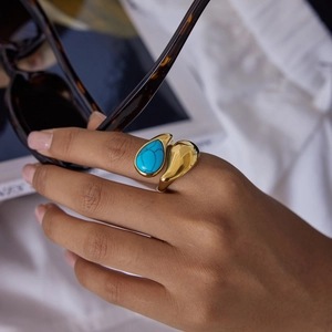 Adjustable gold plated titanium steel ring featuring a pear-shaped natural blue stone