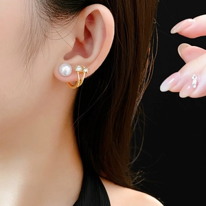 Gros plan de boucles d'oreilles perles et strass portées par un mannequin de mode