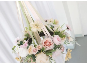 Detail of floral hanging wreath with pink roses, daisies, and pastel ribbons decoration