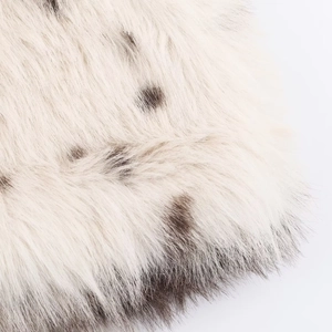 Vue détaillée de la texture de fausse fourrure beige crème avec des taches marron foncé
