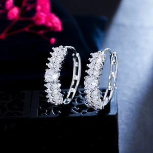 Vue macro de boucles d'oreilles créoles en argent avec double rangée de zircons