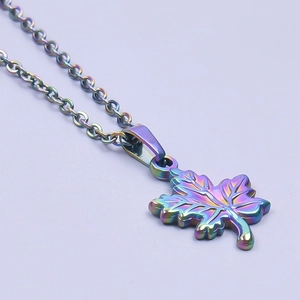 Macro shot of rainbow-colored maple leaf pendant on stainless steel chain link