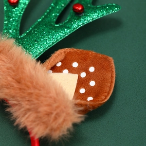 Gros plan de bois de renne verts scintillants avec cloches rouges et oreilles en peluche