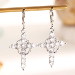 Close-up of silver crown cross earrings featuring sparkling clear cubic zirconia stones