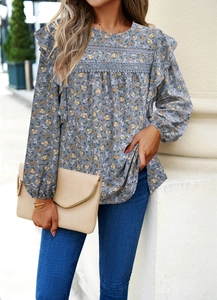 Detailed view of floral blouse featuring lace patchwork and ruffled sleeves on round neck top
