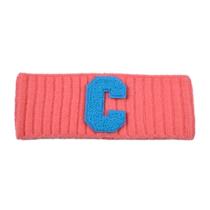Vue macro du bandeau en tricot rose corail avec patch brodé lettre C bleue en éponge