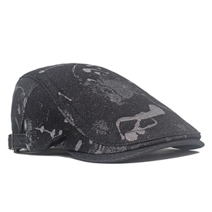 Detail view of denim newsboy cap with abstract print and adjustable metal side buckle