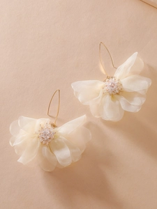 Dettaglio di orecchini a fiore in tessuto bianco fatti a mano con cristalli e ganci oro