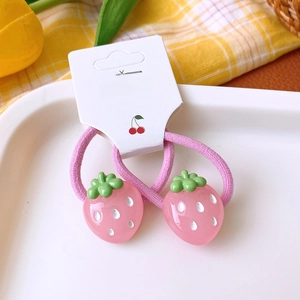 Close-up of pink strawberry hair ties with elastic bands on a white display card