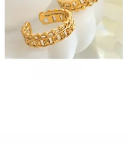 Macro shot of 18k gold plated hollow chain ring with bead edges on a wavy white prop