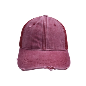 Detalle de gorra de béisbol roja lavada con rejilla trasera y acabados desgastados vintage