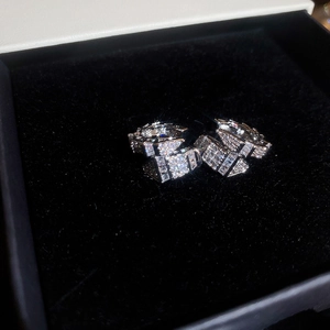 Detailed view of silver C-shaped snake ear cuffs with pave zircons on black velvet