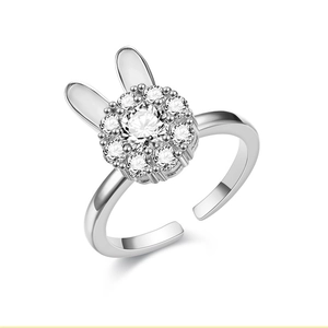 Close-up van zilveren konijnenoor ring met een ronde diamant en sprankelende kristallen