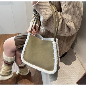 Detail of green fuzzy shoulder bag with white faux shearling trim on a cozy knit outfit