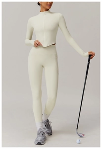 Détail de l'ensemble de yoga blanc crème avec haut zippé ajusté et legging taille haute