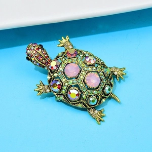 Detailed close-up of a gold turtle brooch adorned with vibrant multicolor crystals