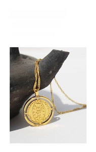 Detail of rotating coin pendant necklace with saint relief and white rhinestones