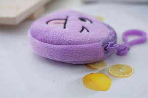 Close-up of purple plush coin purse with embroidered wink emoji and matching plastic hook