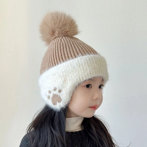 Detail of warm winter knit hat for boys featuring bear paw embroidery and a fuzzy pompom