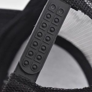 Close-up of adjustable plastic snapback strap and breathable black mesh on cotton cap