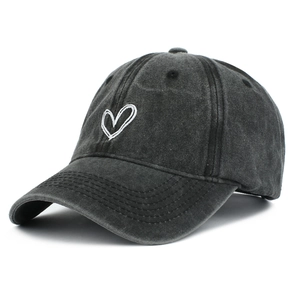 Close-up of heart embroidery on washed cotton baseball cap with vintage charcoal texture
